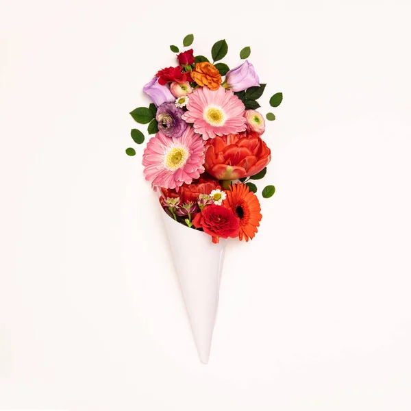 Ramo de flores en cono de papel sobre fondo blanco — Foto de Stock