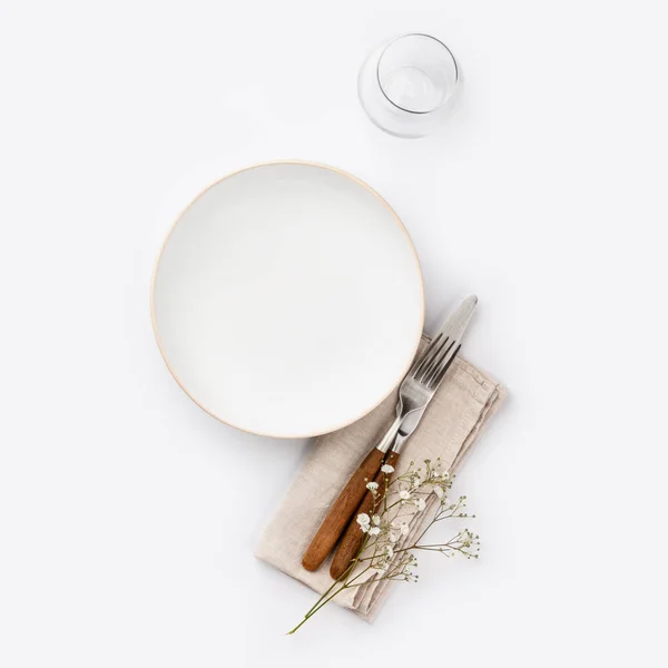 Пустая белая тарелка и столовые приборы на салфетке — стоковое фото
