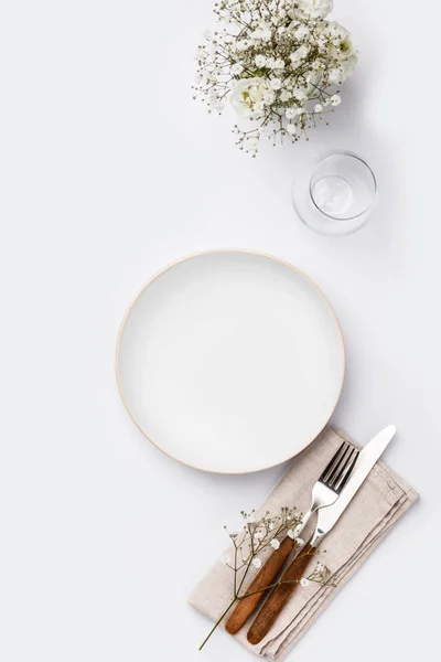 Empty white plate and cutlery on a napkin — Stock Photo, Image