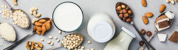 Vegan milk and ingredients on rustic background, flat lay — Stock Photo, Image