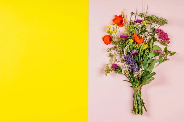 Wild flower bouquet on pink and yellow background — Stock Photo, Image