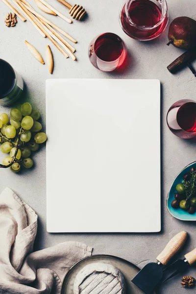 Vino tinto con surtido de charcutería sobre fondo de hormigón rústico — Foto de Stock