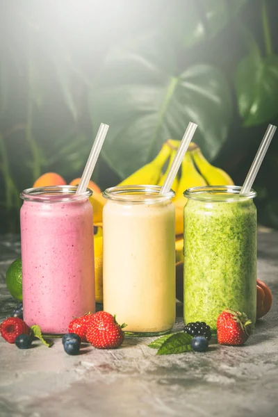 Fresh smoothies on tropical background, close up