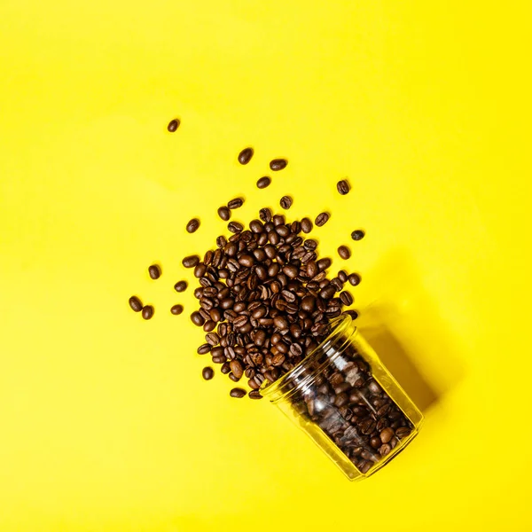 Kaffebönor på gul bakgrund, platt lekmanna, ovanifrån — Stockfoto