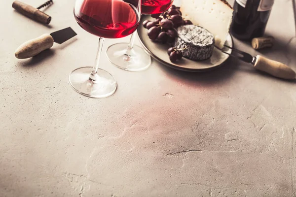 コンクリートの背景に赤ワインとチーズ — ストック写真