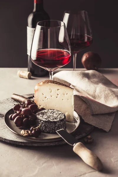 Meyve ve fındık ile kırmızı şarap ve peynir tabağı — Stok fotoğraf