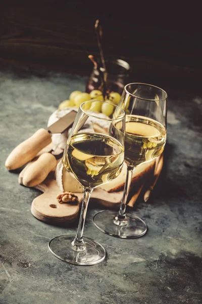 Vino blanco con surtido de charcutería sobre fondo de piedra —  Fotos de Stock