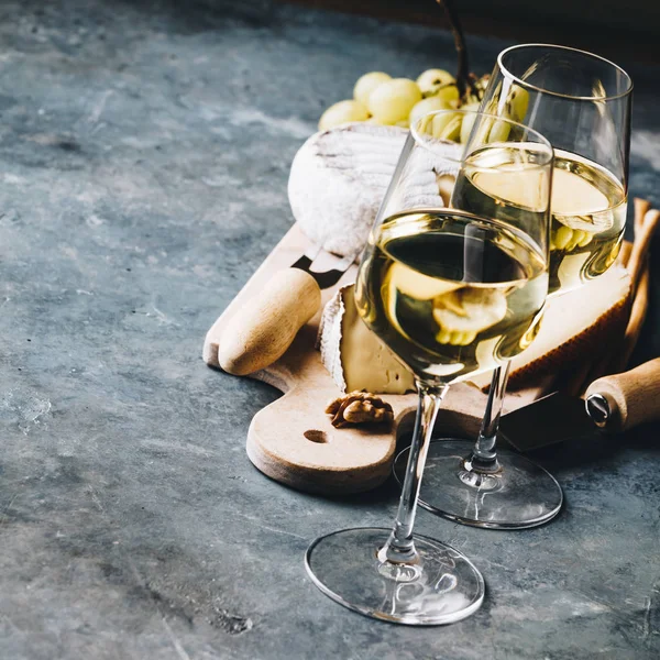Vino blanco con surtido de charcutería sobre fondo de piedra —  Fotos de Stock