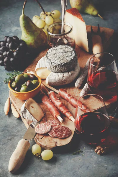 Vino rosso con assortimento di salumi sullo sfondo in pietra — Foto Stock