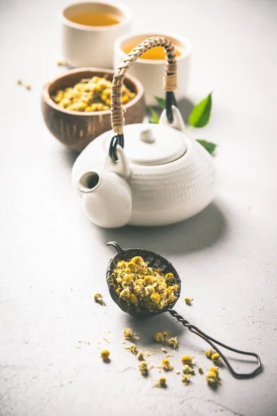 Chamomile tea in strainer on vintage background — Stock Photo, Image