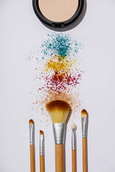 Makeup brushes and cosmetic products on a white background — Stock Photo, Image