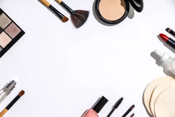 Brosses de maquillage et produits cosmétiques sur fond blanc — Photo