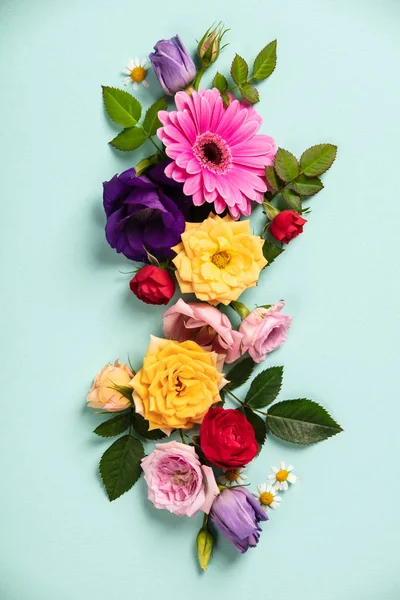 Creatieve lay-out gemaakt met prachtige bloemen op blauwe achtergrond. Platte lag. Lente minimal concept — Stockfoto