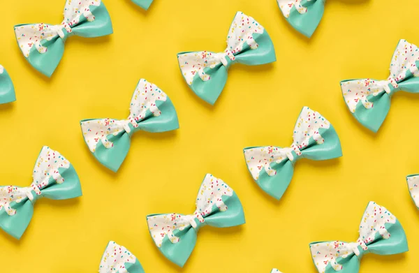 Cute hair bow pattern on bright background, flat lay
