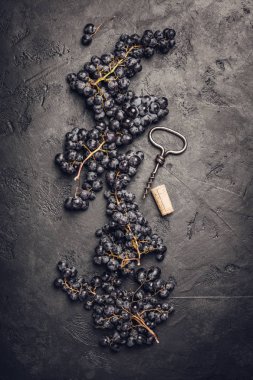 Taze üzüm, mantar ve tirbuşon koyu arka plan üzerinde