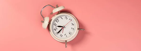 ピンクの背景に白い目覚まし時計-パターン — ストック写真