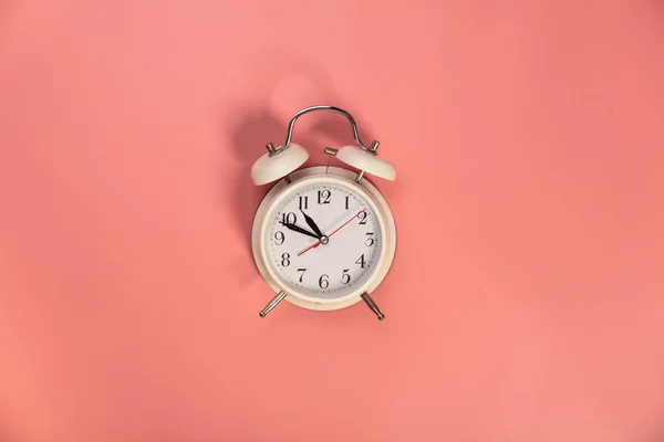 Vit väckarklocka på rosa bakgrund - platt låg — Stockfoto