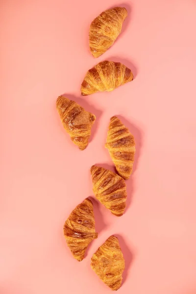 Deliciosos mini cruasanes frescos sobre fondo rosa —  Fotos de Stock