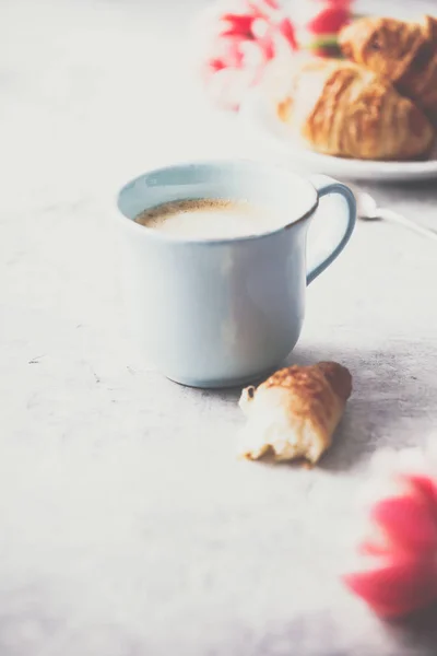 Açık gri arka planda sabah kahvesi, kruvasan ve bahar laleleri — Stok fotoğraf