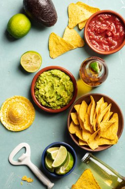 Nachos, guacamole, salsa ve mavi arka plan üzerinde bira