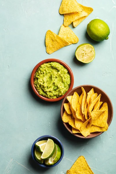 Nachos ve mavi arka plan üzerinde taze ev yapımı guacamole — Stok fotoğraf