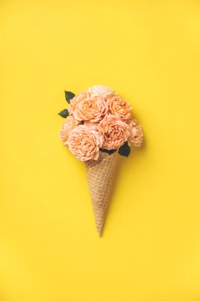 Fagylalt kúp rózsaszín rózsával, sárga háttérrel — Stock Fotó