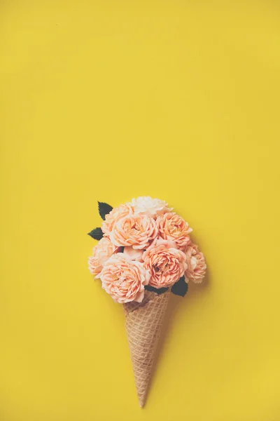 Παγωτό χωνάκι με ροζ τριαντάφυλλα σε κίτρινο φόντο — Φωτογραφία Αρχείου