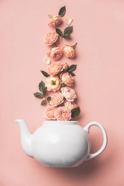 粉红底色橙色玫瑰白色茶壶的创意布局 — 图库照片