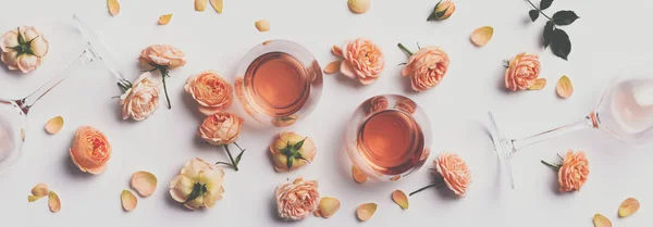 Vino rosato e rose su sfondo bianco — Foto Stock