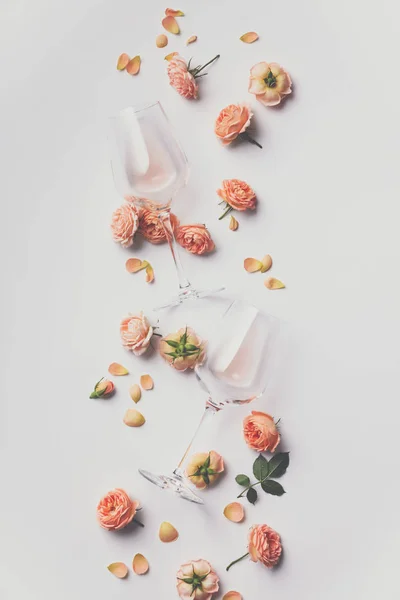 Розовое вино и розы на белом фоне — стоковое фото