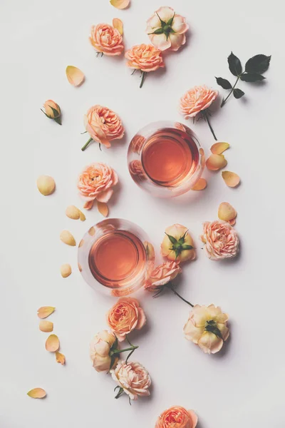 Ροζέ κρασί και τριαντάφυλλα σε λευκό φόντο — Φωτογραφία Αρχείου
