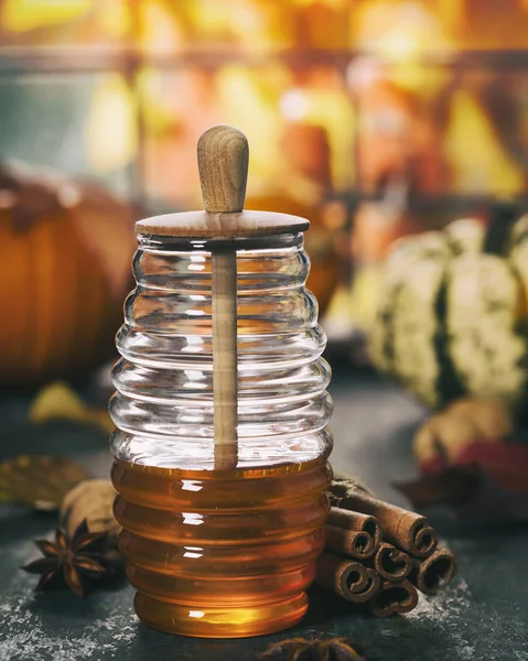Warme und gemütliche Herbstkomposition. Glas mit Honig, Kürbissen und Gewürzen. — Stockfoto