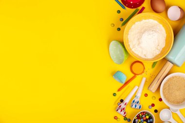 Sarı arka plan üzerinde doğum günü cupcakes malzemeler pişirme, düz yatıyordu