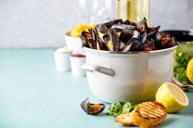 Limon, otlar, kruton ve patates kızartması ile beyaz şarap Belçika midye