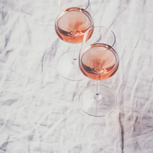 Vin rose dans des verres sur toile de lin blanche — Photo