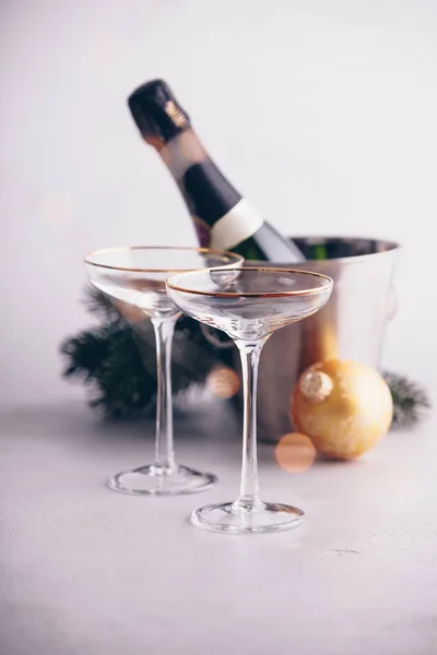 Bottiglia di champagne in secchio con ghiaccio, bicchieri e addobbi natalizi — Foto Stock