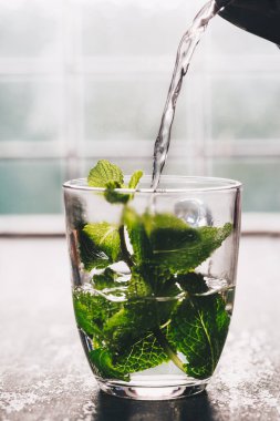 Pencerenin yanında taze nane çayı. Rahat ev ya da sağlık kavramı