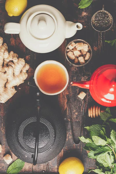 Teekomposition auf rustikalem Hintergrund: Tee, Minze, Zitrone, Ingwer. — Stockfoto