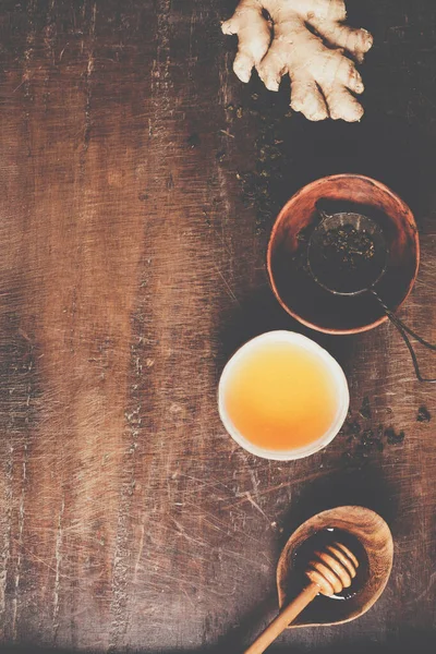 Composición del té sobre fondo rústico: té, menta, limón, jengibre . —  Fotos de Stock