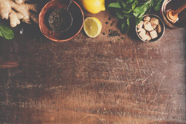 Teekomposition auf rustikalem Hintergrund: Tee, Minze, Zitrone, Ingwer. — Stockfoto