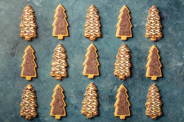 Kerst peperkoek koekjes in de vorm van een kerstboom op blauwe achtergrond — Stockfoto