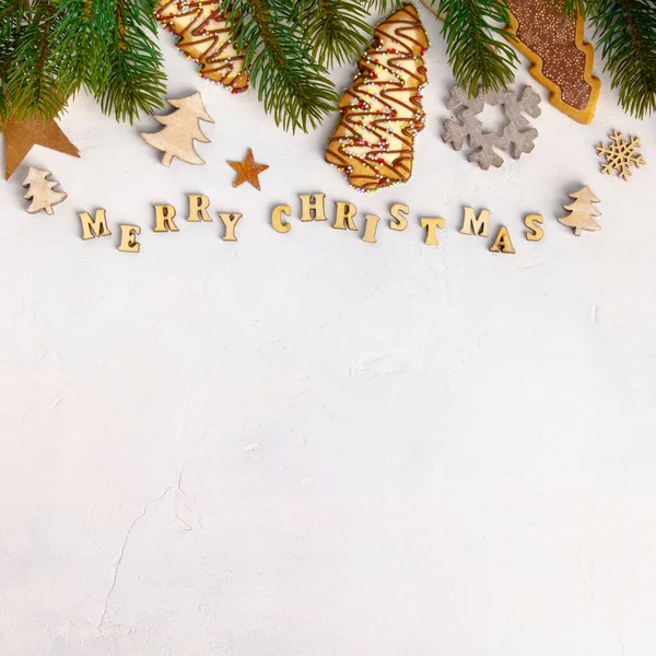Veselé Vánoce napsané dřevěnými dopisy, koláčky a vánočními dekoracemi — Stock fotografie