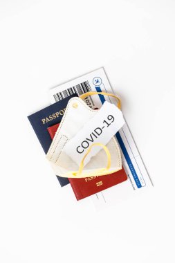 Coronavirus ve seyahat konsepti. Pasaportlar, uçak biletleri, dezenfektan, termometre ve tıbbi maske düzleştirildi.