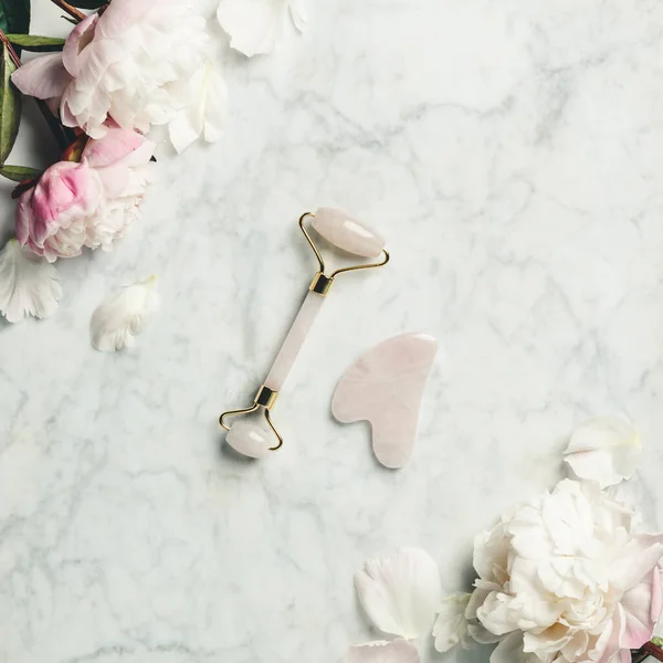 美しい顔のマッサージ療法とピンクの牡丹のためのジェイドフェイスローラー — ストック写真