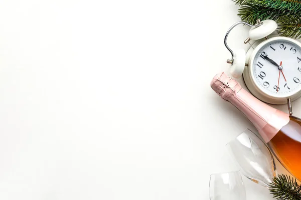 Composição de Natal ou Ano Novo em fundo branco com despertador retro, garrafa de champanhe, copos e decorações de Natal — Fotografia de Stock