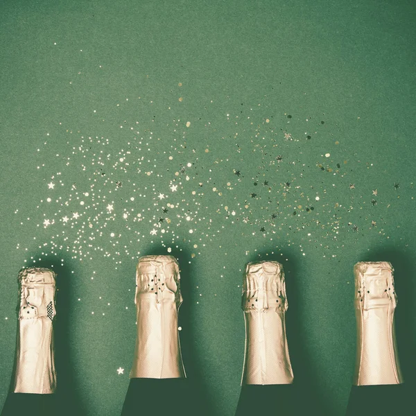 Altın parıltılı şampanya şişeleri ve yeşil arkaplanda yazı için yer — Stok fotoğraf