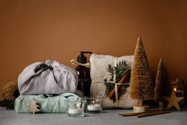 Cadeaux enveloppés de tissu, soins du corps de beauté zéro déchet et articles de nettoyage de maison et décorations de Noël en bois — Photo