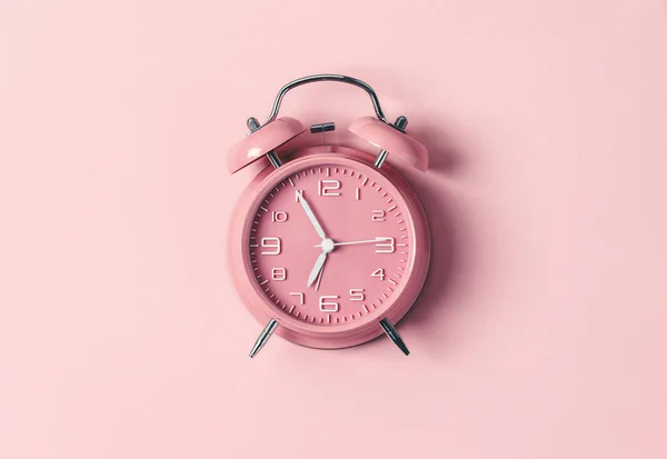 Pink alarm clock on pink background, flat lay, top view — Stock Photo, Image