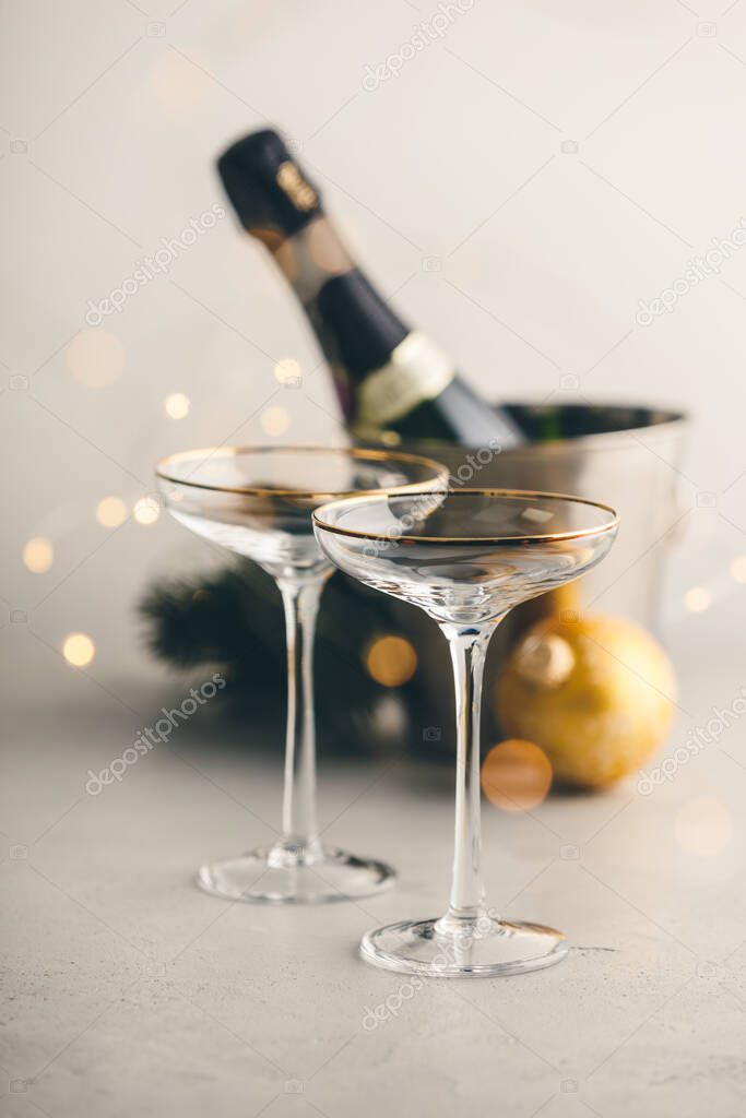 Champagne bottle in bucket with ice, glasses and Christmas decorations