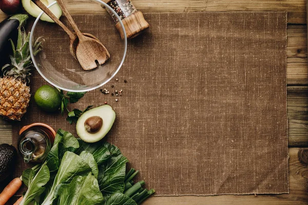 Fresh organic ingredients for salad making on rustic background